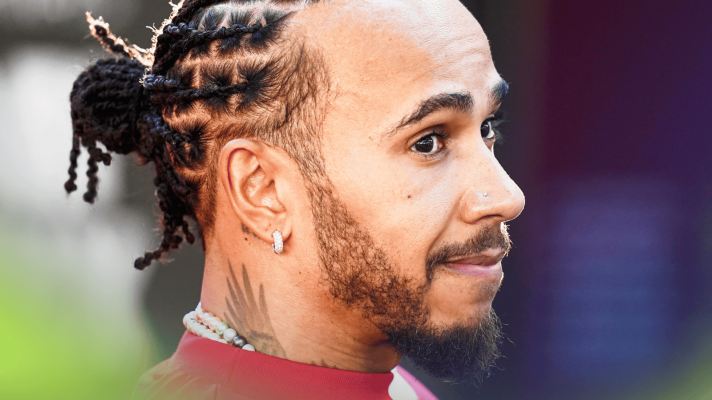 Lewis Hamilton looks on with a raised eyebrow in the Abu Dhabi paddock