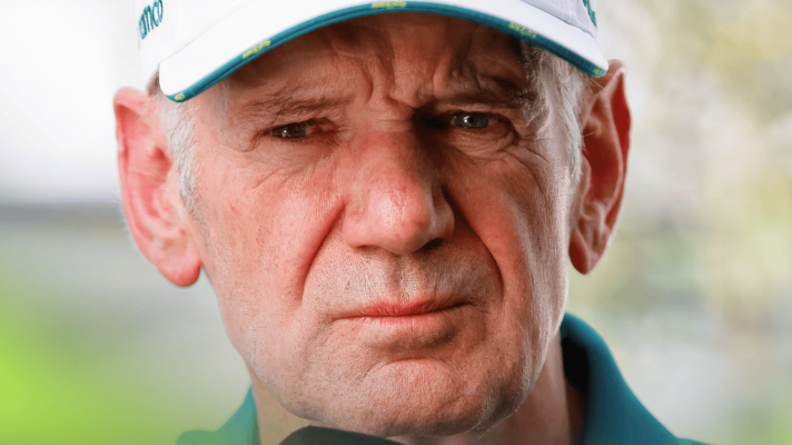 A close-up shot of Adrian Newey wearing a white Aston Martin cap