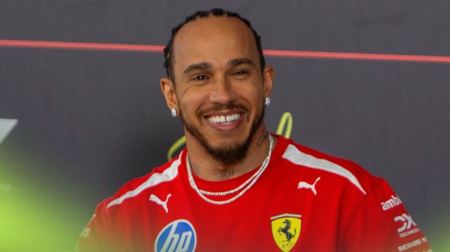 Ferrari driver Lewis Hamilton smiles in a press conference.