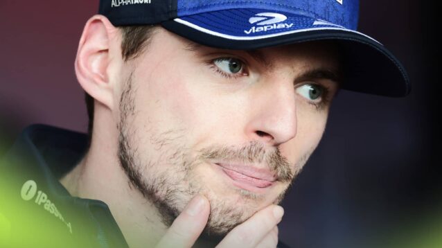 A close-up shot of Max Verstappen holding his hand to his chin