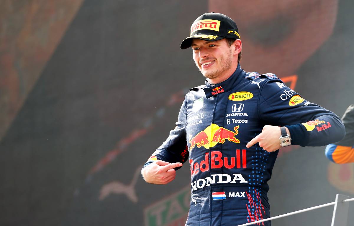 Max Verstappen points to the Red Bull logo while celebrating Austrian GP victory. July, 2021.