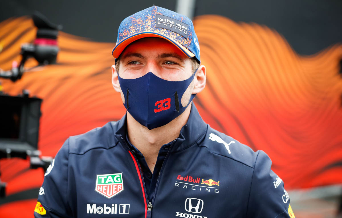 Max Verstappen smiles behind his mask.