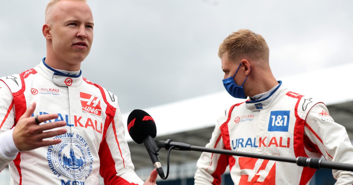 Haas driver Nikita Mazepin speaks with Mick Schumacher standing behind him. Britain July 2021