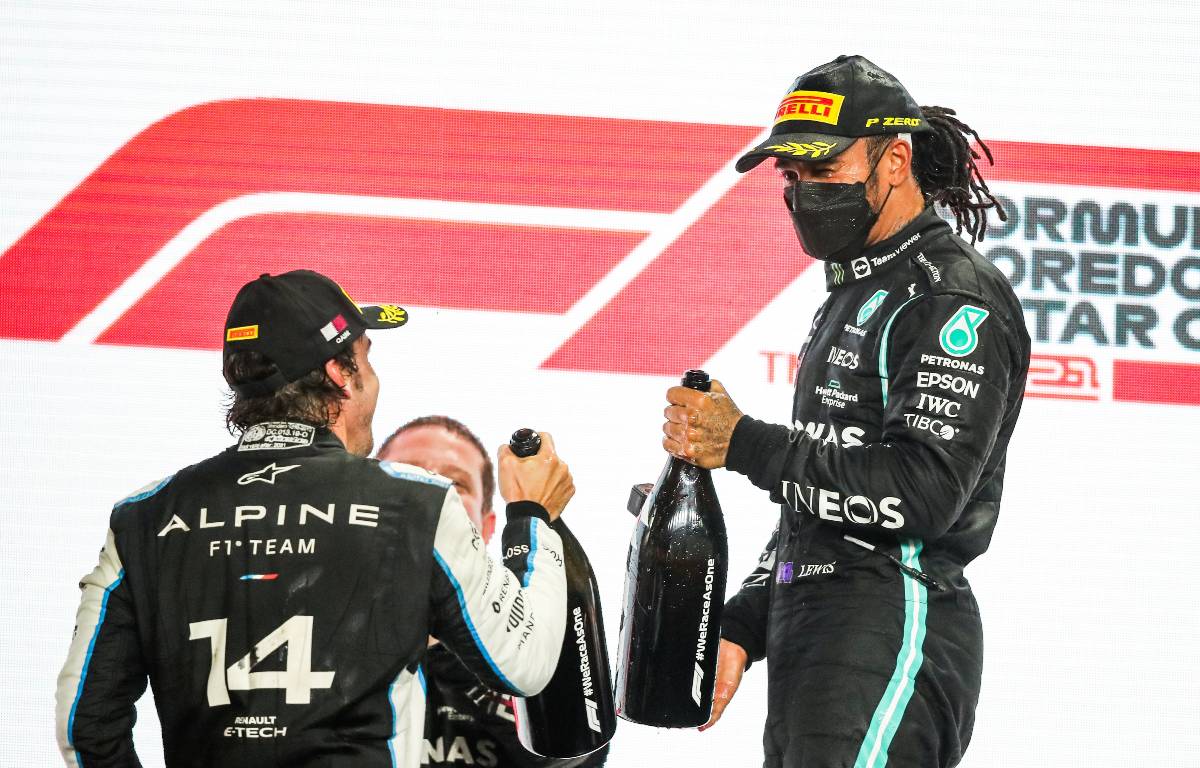 Lewis Hamilton and Fernando Alonso clinking bottles. Qatar November 2021.