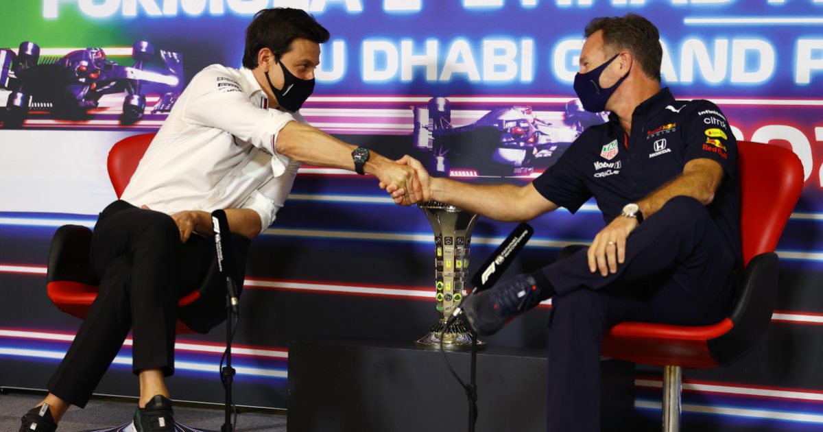 Toto Wolff and Christian Horner shake hands at a press conference. Yas Marina December 2021.