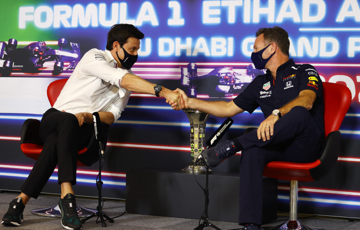 Toto Wolff and Christian Horner shake hands at a press conference. Yas Marina December 2021.