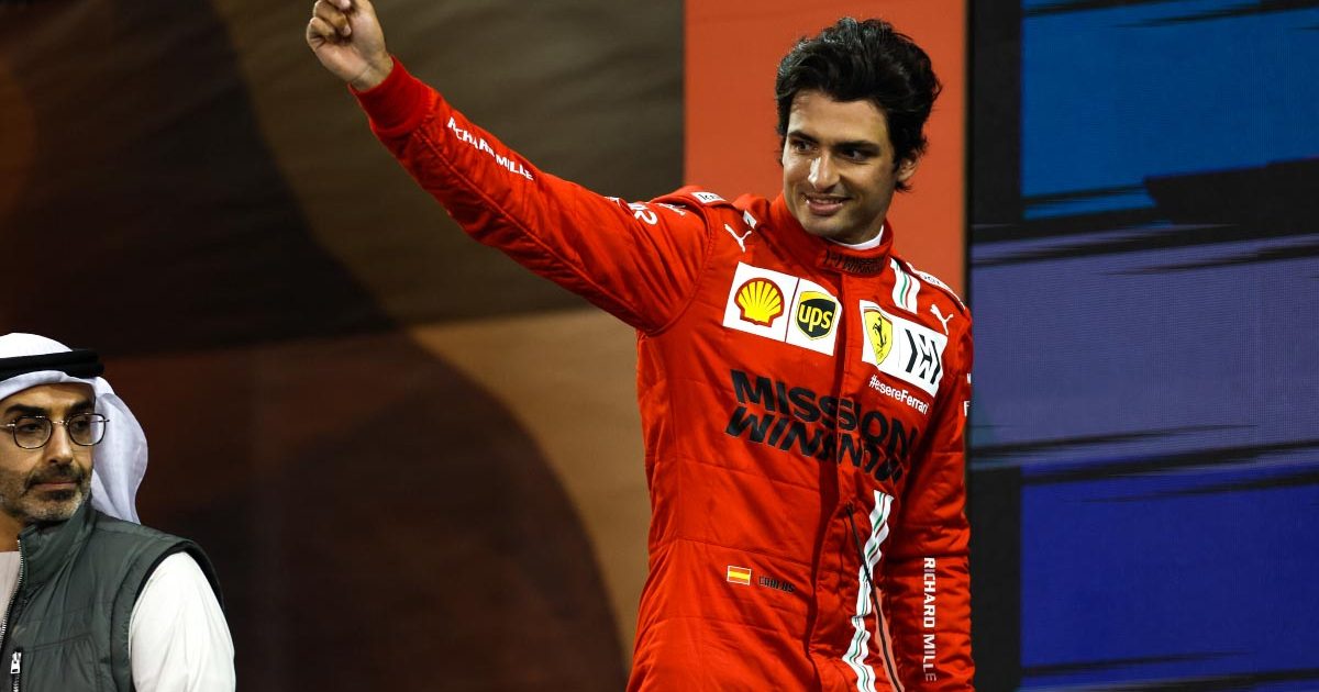 Carlos Sainz waves his hat on the podium. Abu Dhabi December 2021.