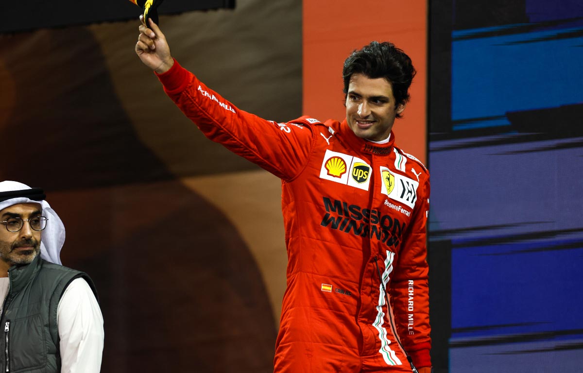 Carlos Sainz waves his hat on the podium. Abu Dhabi December 2021.