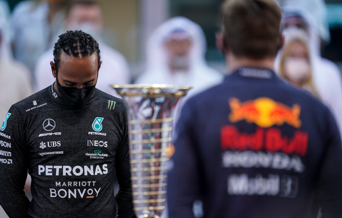 Lewis Hamilton looking down Drivers Championship trophy and Max Verstappen. Abu Dhabi December 2021
