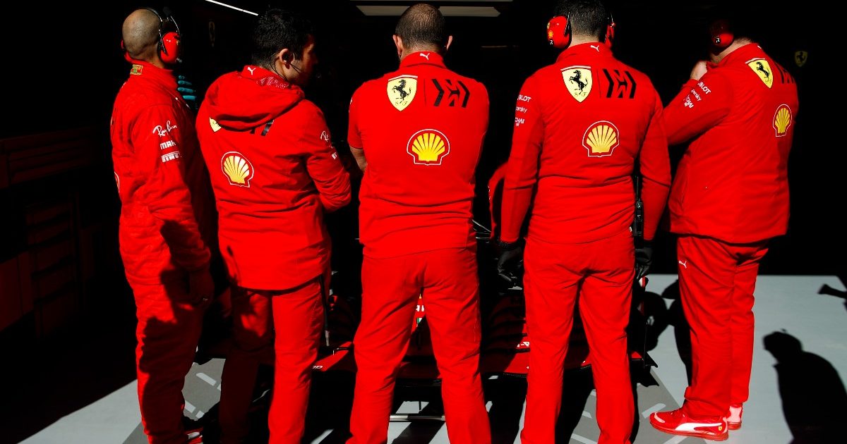 Ferrari mechanics block the view of their car. Spain, February 2020.