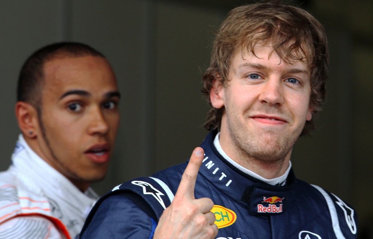 Sebastian Vettel shows the '1' fingers as Lewis Hamilton looks on. Australia, March 2011.