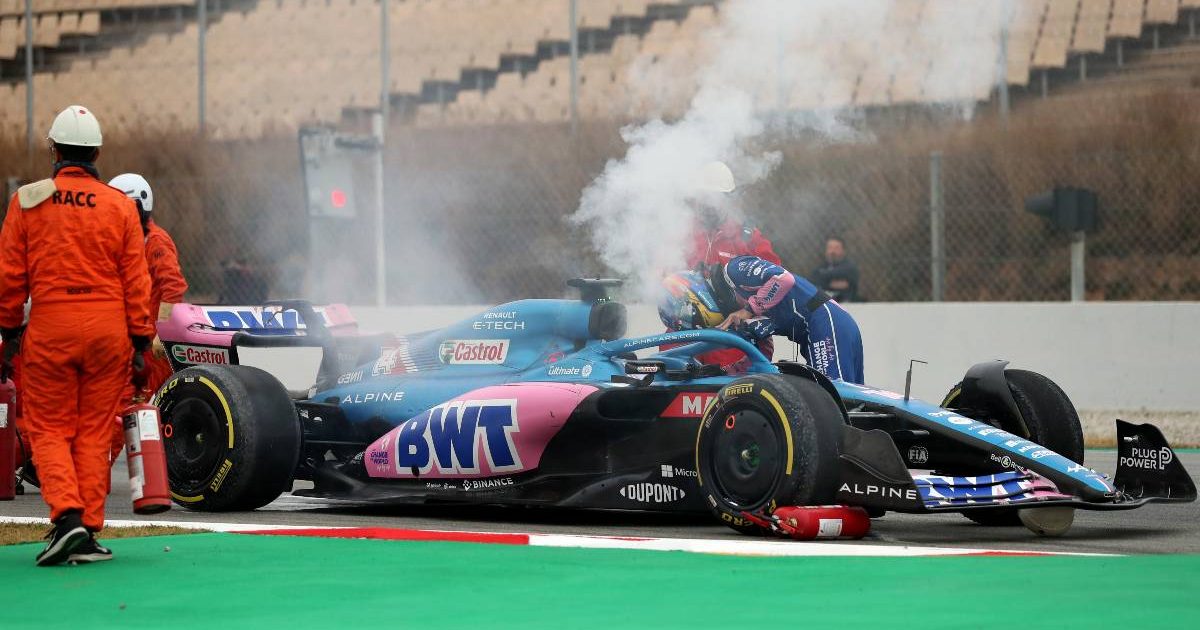 Fernando Alonso checks over his smoking Alpine during the track session at the Circuit de Catalunya. Barcelona February 2022.