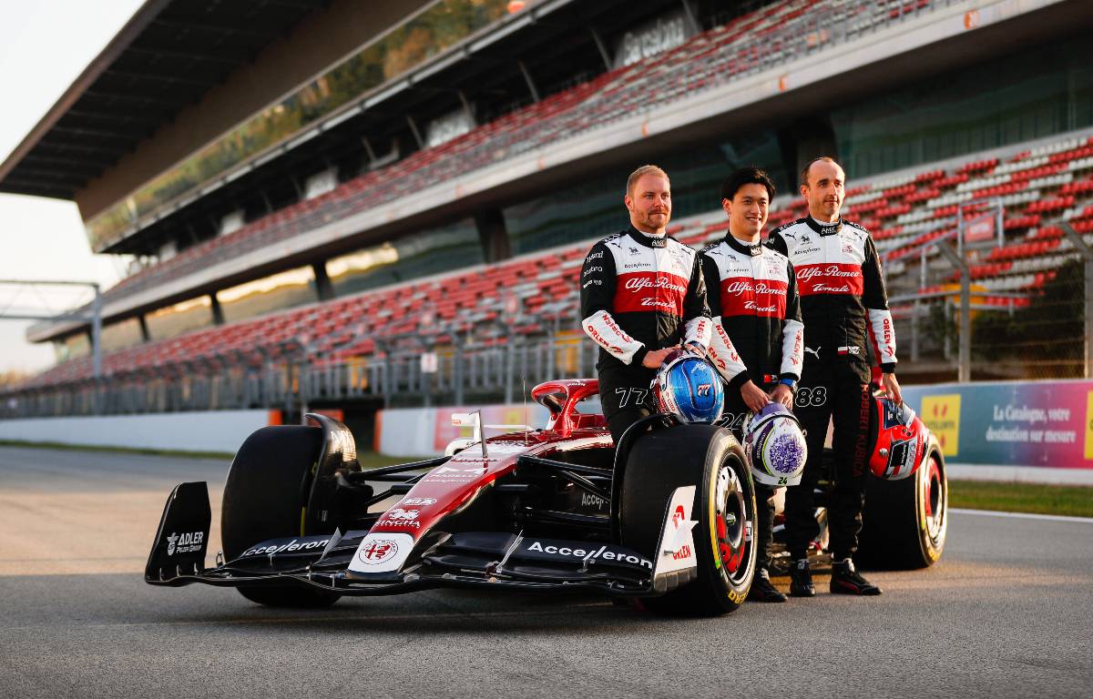 Valtteri Bottas, Guanyu Zhou and Robert Kubica stand next to the Alfa Romeo C42. Barcelona February 2022.