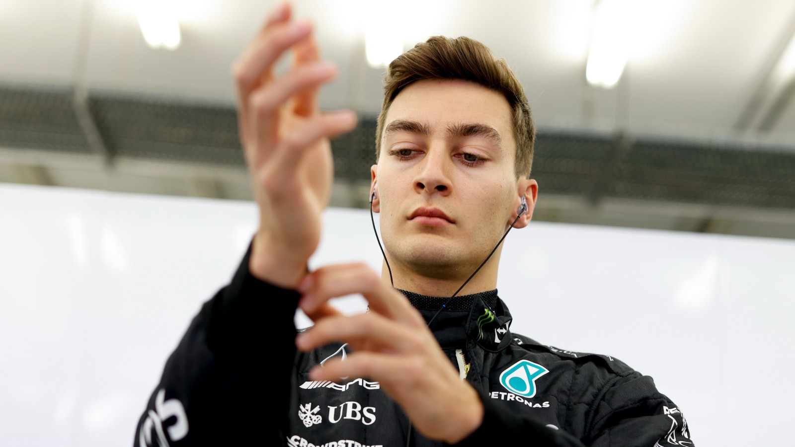 George Russell, Mercedes, adjusts his sleeve. Bahrain, March 2022.