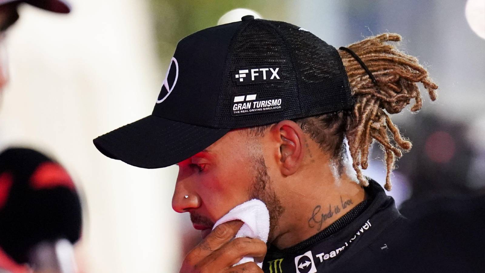 Lewis Hamilton wipes his face after a race. Bahrain March 2022.