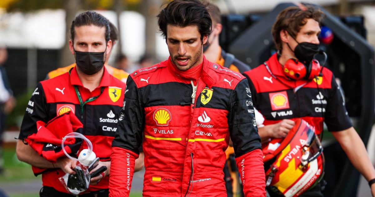 Carlos Sainz walks head down with Ferrari team members. Australia, April 2022.