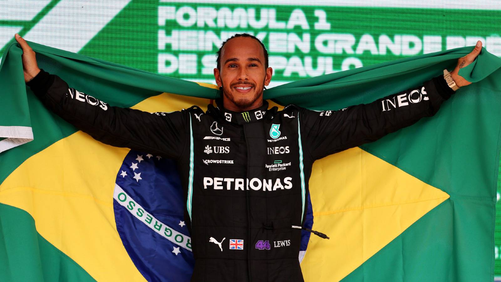 Lewis Hamilton celebrates with a Brazilian flag on the podium. Interlagos November 2021.