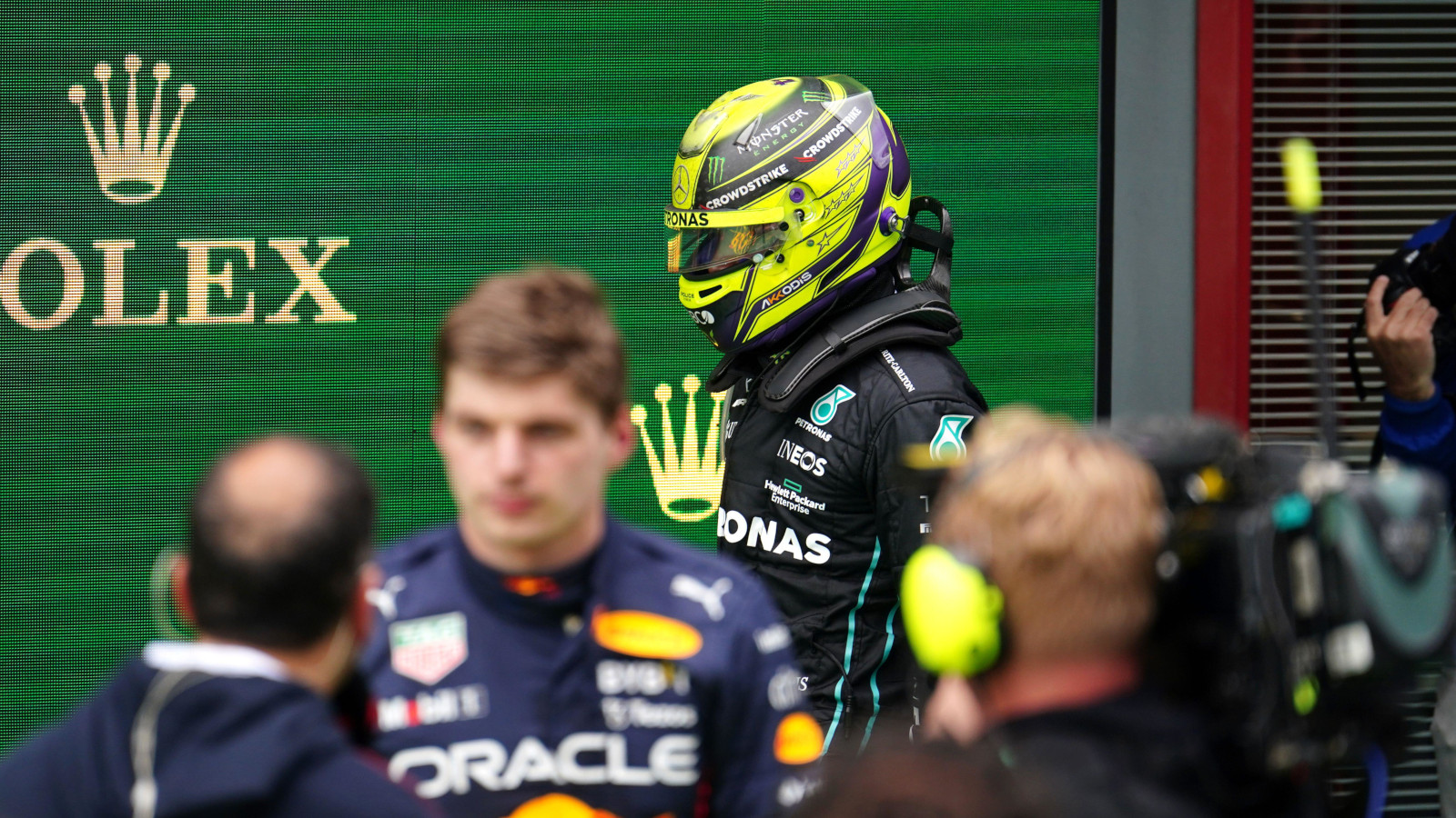 Lewis Hamilton walks past as Max Verstappen does interviews. Imola April 2022
