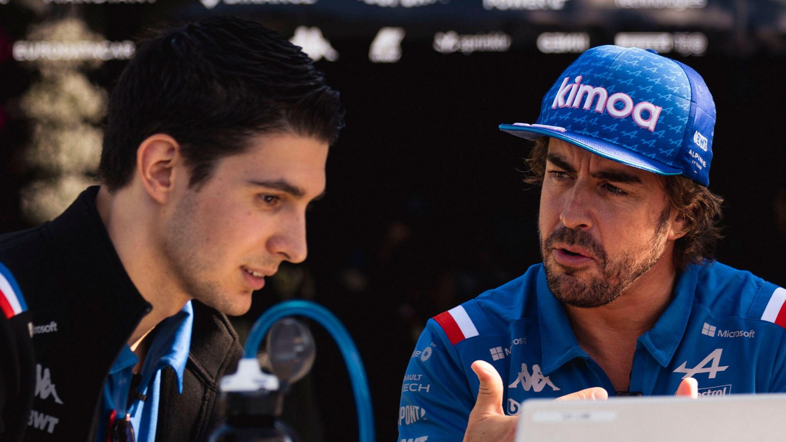 Fernando Alonso and Esteban Ocon look at a laptop. Melbourne, April 2022.