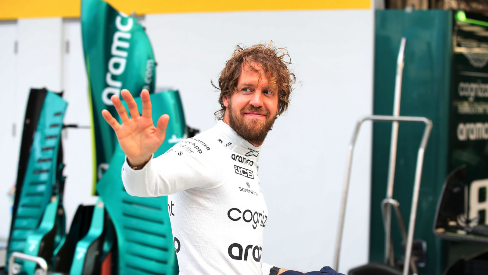 Sebastian Vettel walks into the Aston Martin garage waving. Miami May 2022