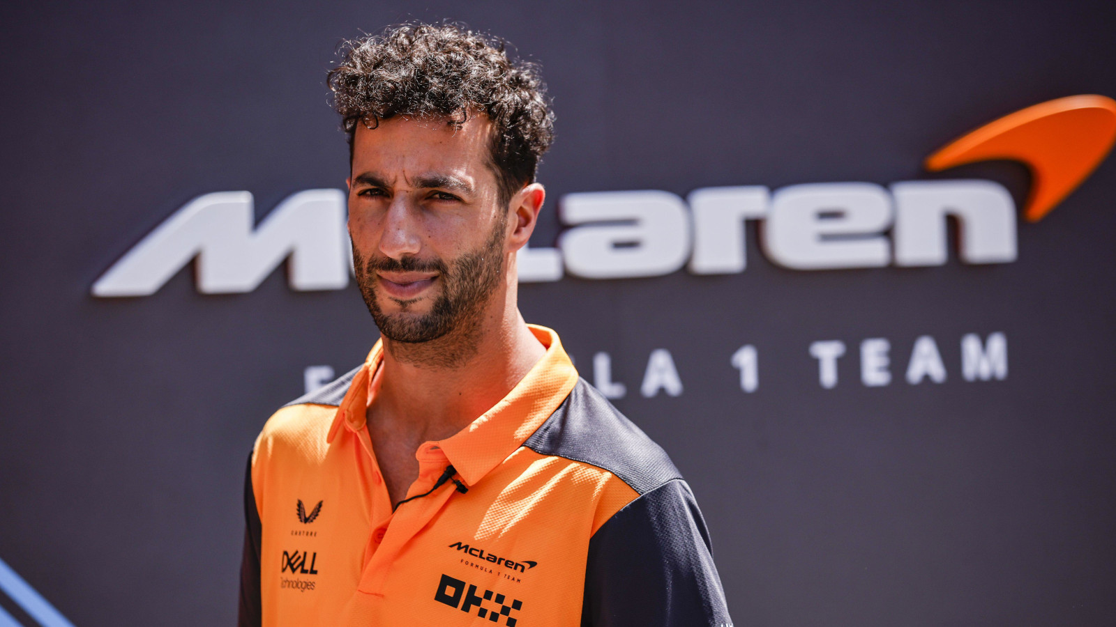 Daniel Ricciardo standing in front of McLaren signage. Spain May 2022