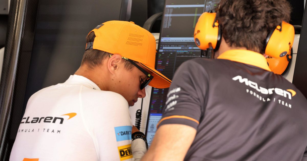 Lando Norris with his head bowed as he looks at data. Spain May 2022