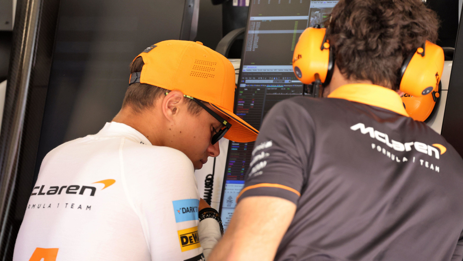 Lando Norris with his head bowed as he looks at data. Spain May 2022