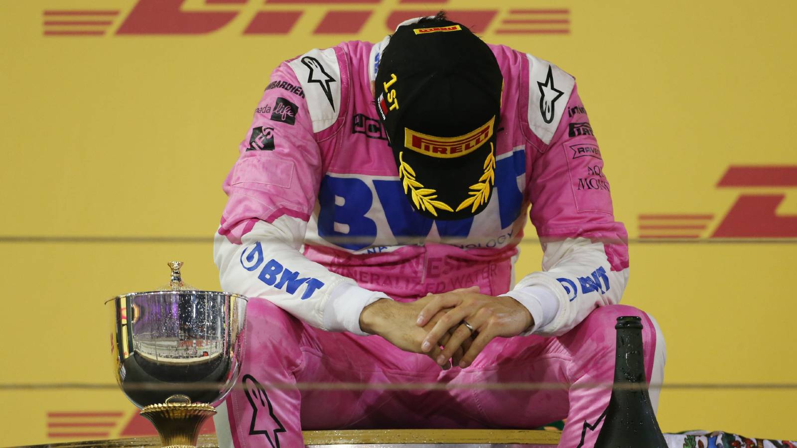 Sergio Perez sitting with head bowed on the podium. Bahrain December 2020.
