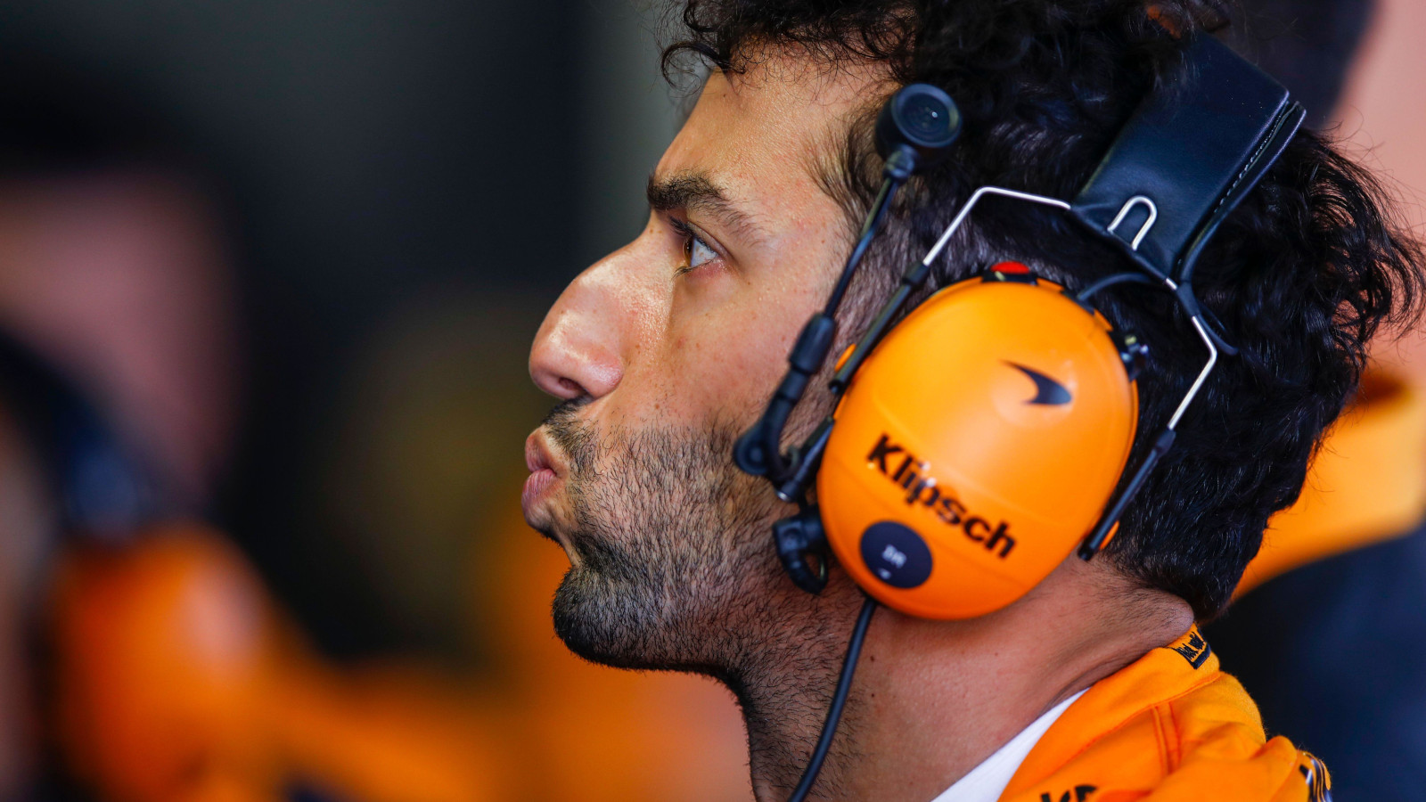 Daniel Ricciardo lips pursed as he watches the monitor. Monaco May 2022