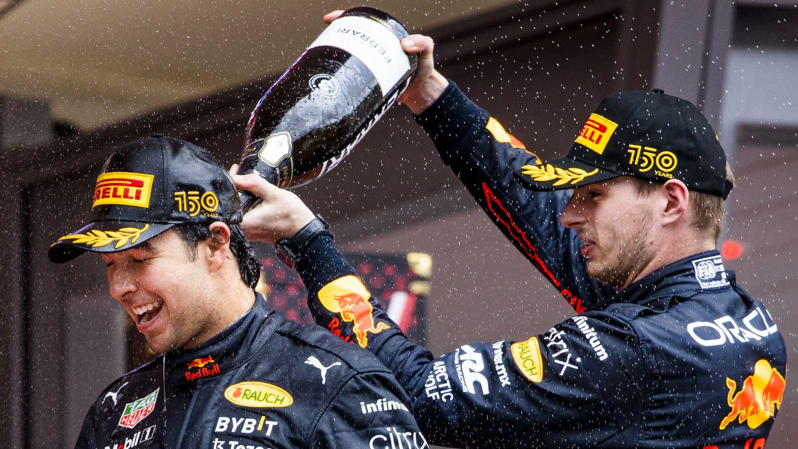 Max Verstappen pours champagne on Sergio Perez. Monaco, May 2022.