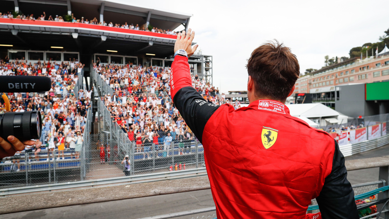 Charles Leclerc with his back to the camera as he waves to the crowd. Monaco May 2022