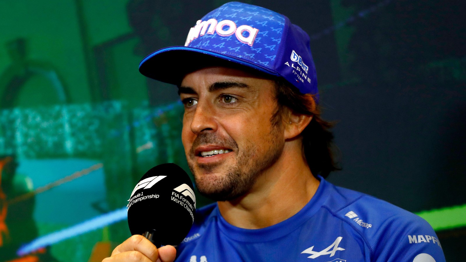 Fernando Alonso smiling whilst holding a microphone. Baku, June 2022.