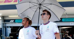 梅赛德斯车队的队友刘易斯·汉密尔顿和乔治·拉塞尔站在一把伞下。阿塞拜疆，2022年6月。