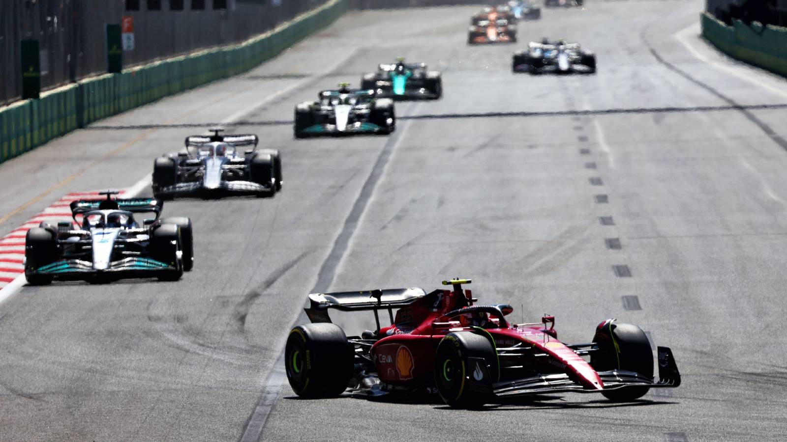 Carlos Sainz's Ferrari heads a train of cars. Baku June 2022.
