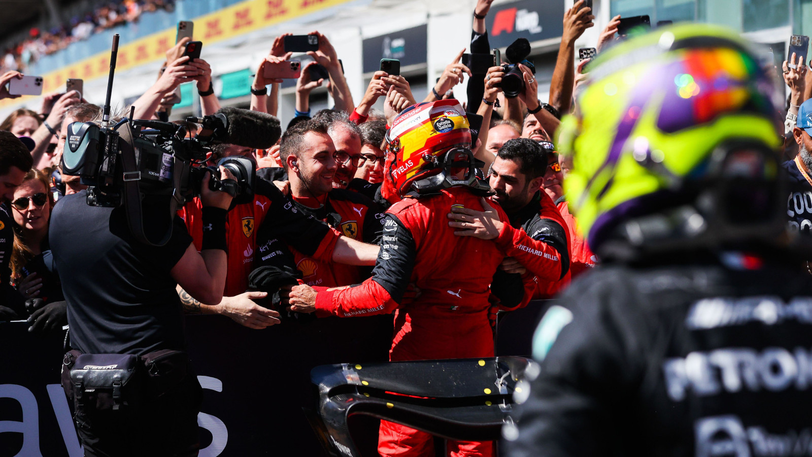 Carlos Sainz celebrates with Ferrari, Lewis Hamilton in the foreground. Montreal June 2022