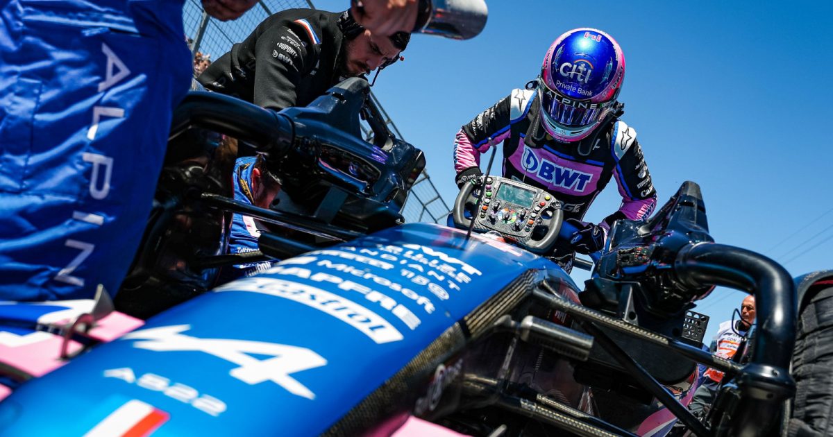 Fernando Alonso climbs into his car on the grid, steering wheel on the nosecone. Montreal June 2022