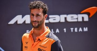 Daniel Ricciardo standing with McLaren signage behind him. Spain May 2022