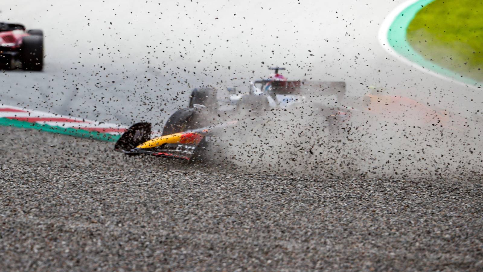 Sergio Perez, Red Bull, slides through the gravel after contact with George Russell, Mercedes. Austria, July 2022.