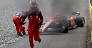 法拉利车手卡洛斯·塞恩斯在引擎故障后从燃烧的汽车中逃离。斯皮尔伯格,2022年7月。