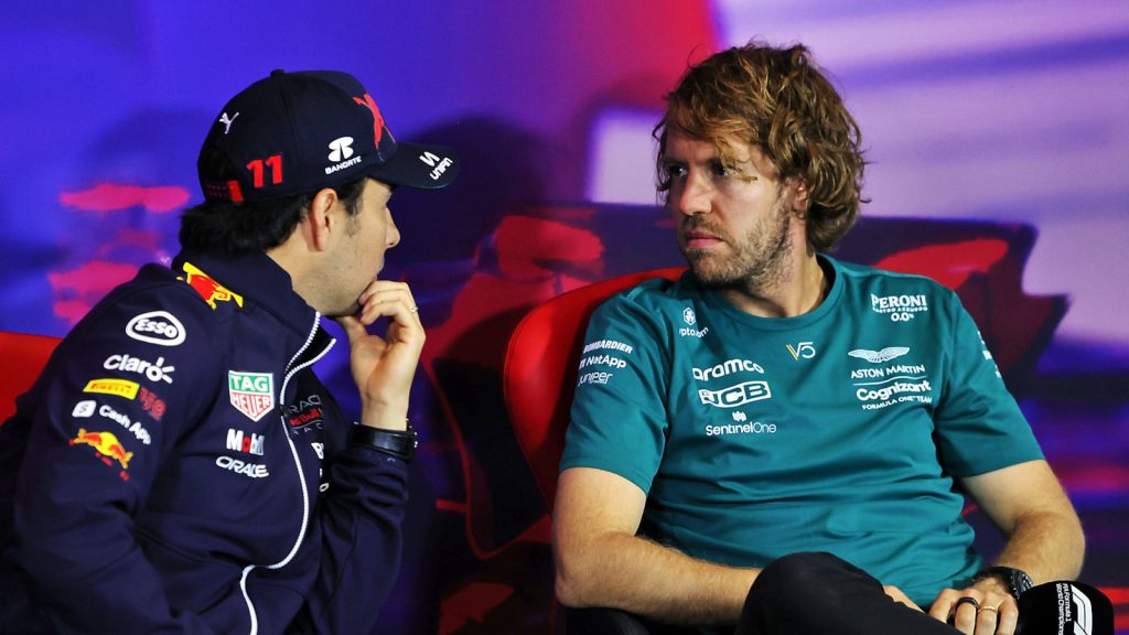 Sergio Perez speaking with a serious Sebastian Vettel during a press conference. Silverstone July 2022