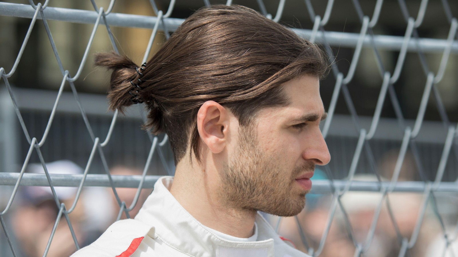 Formula E driver Antonio Giovinazzi stood near a fence. Germany, May 2022.