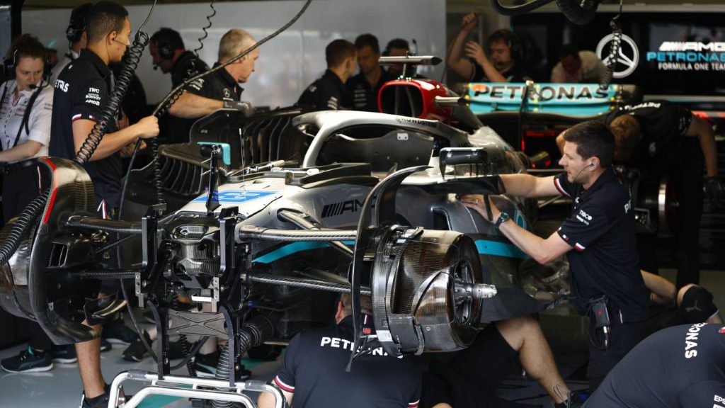 Mercedes mechanics work on George Russell's car. Red Bull Ring July 2022.