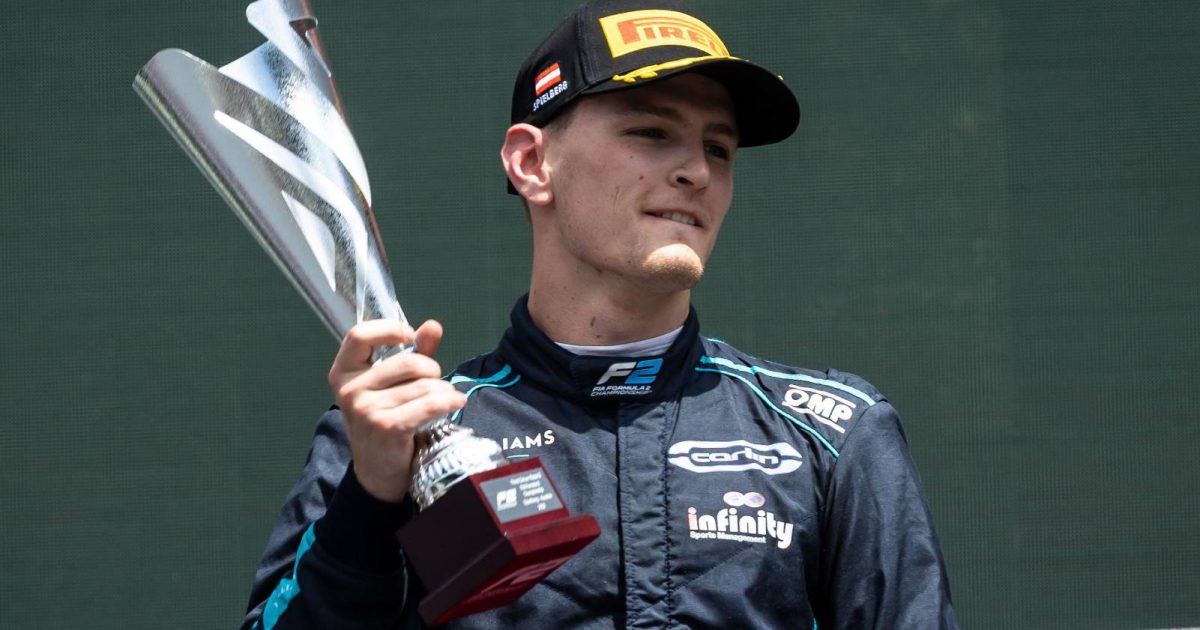 Logan Sargeant holds his trophy on the podium. Red Bull Ring July 2022.
