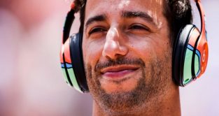 丹尼尔·里夏尔多(Daniel Ricciardo)戴着耳机听音乐，面带微笑。摩纳哥2022年5月