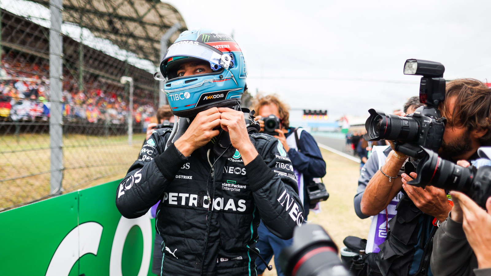 George Russell putting on his helmet on the grid surrounded by photographers. Hungary July 2022