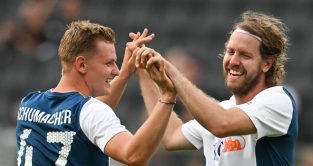 米克·舒马赫和塞巴斯蒂安·维特尔在慈善足球赛上击掌。德国，2022年8月。