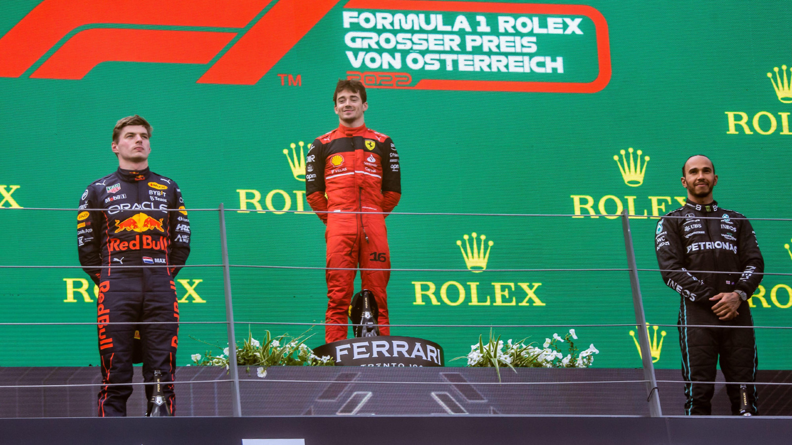 Red Bull's Max Verstappen, Ferrari's Charles Leclerc, and Mercedes' Lewis Hamilton on the podium at the Austrian Grand Prix. Spielberg, July 2022.