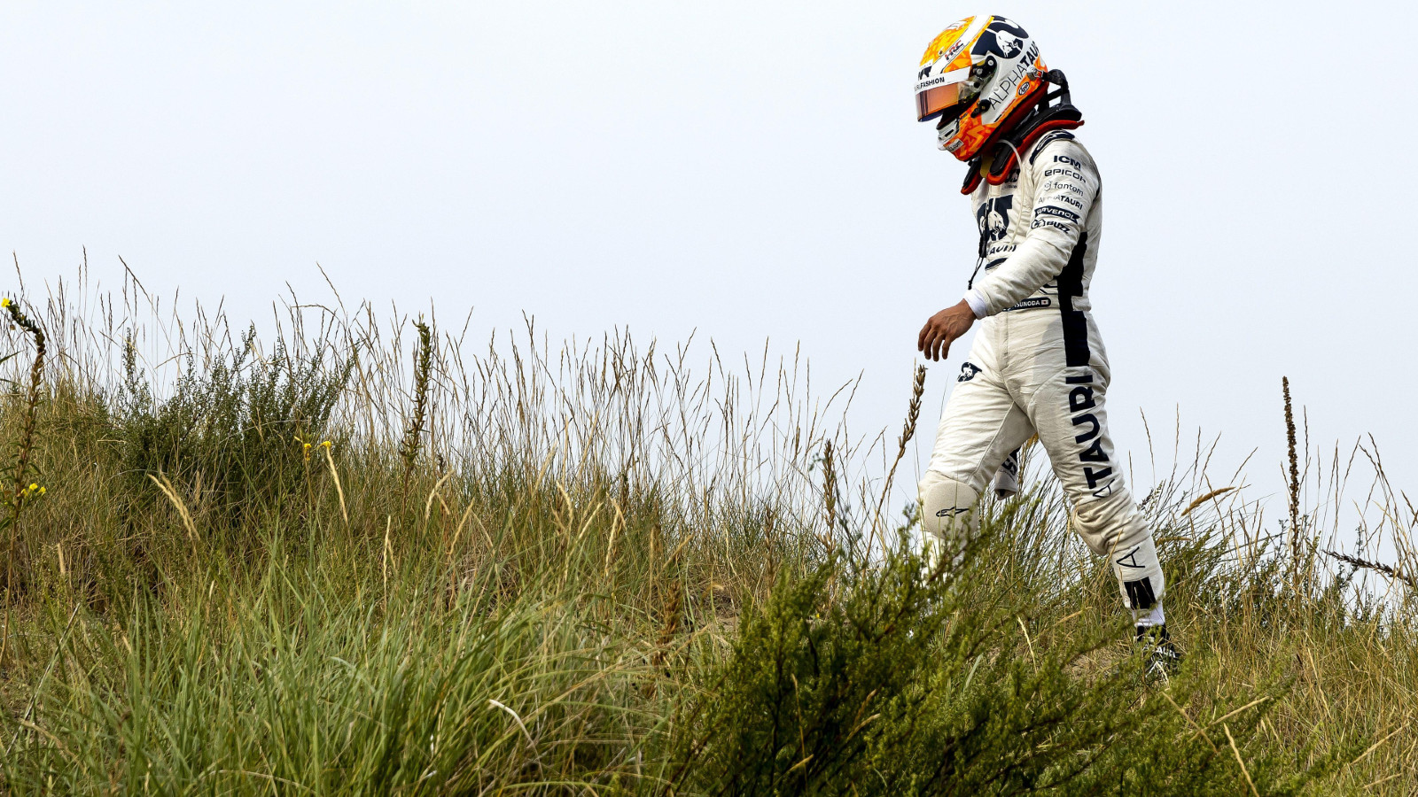 AlphaTauri's Yuki Tsunoda walks back to the pits after retiring from the Dutch Grand Prix. Zandvoort, September 2022.