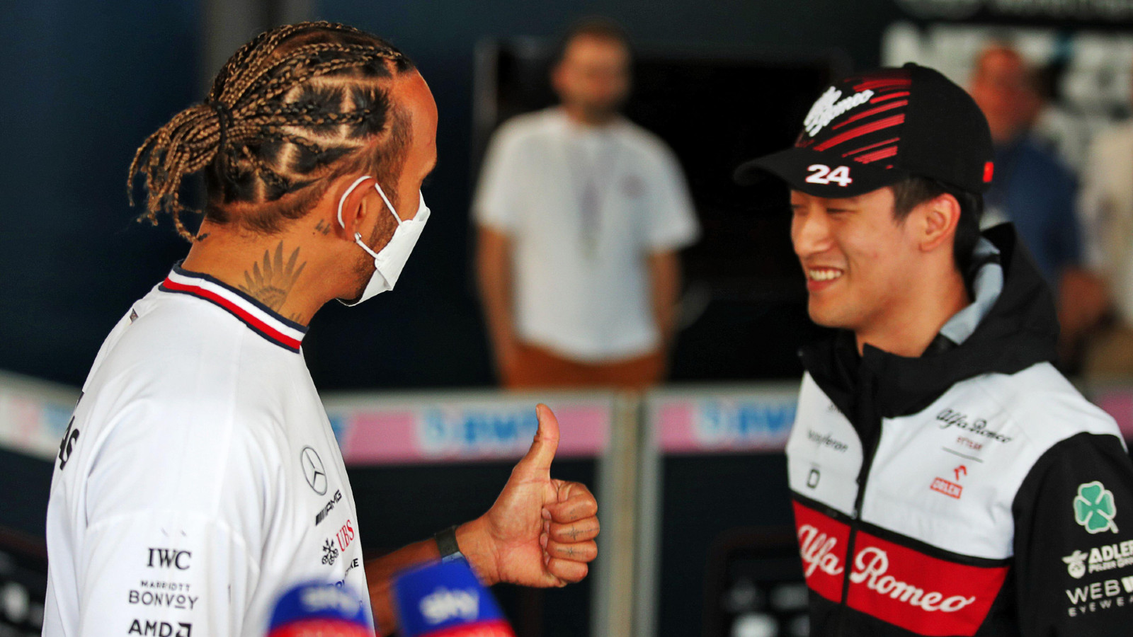 Alfa Romeo's Zhou Guanyu chats with Mercedes' Lewis Hamilton at the Austrian Grand Prix. Red Bull Ring, July 2022.