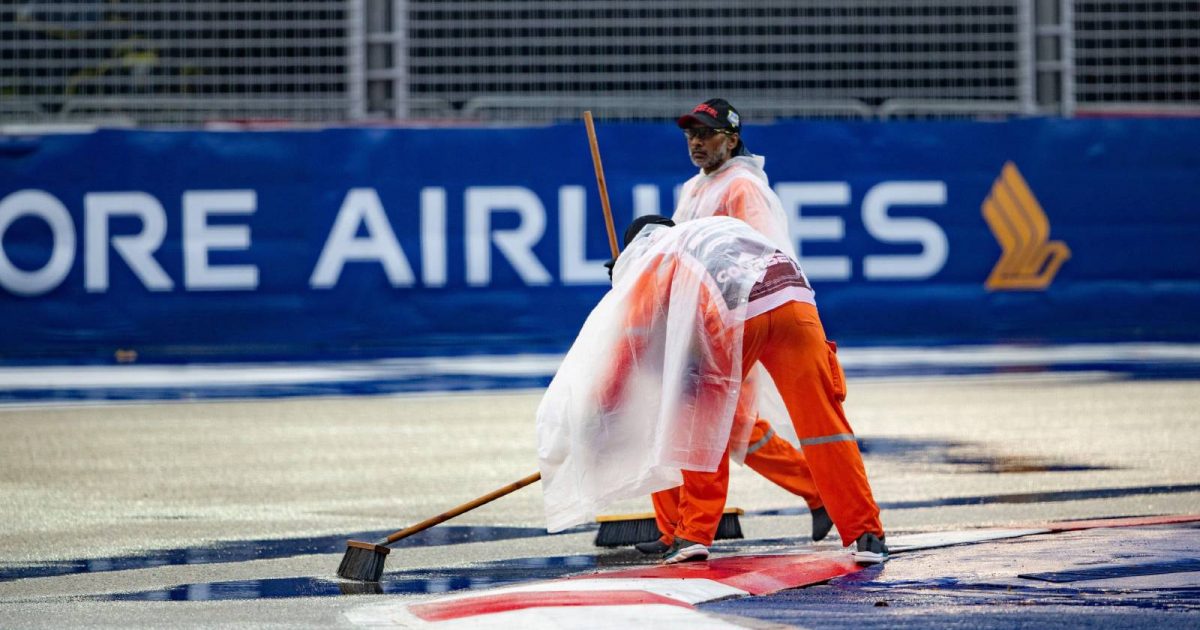 法警把雨水从赛道上扫走。新加坡的全科医生。2022年10月。